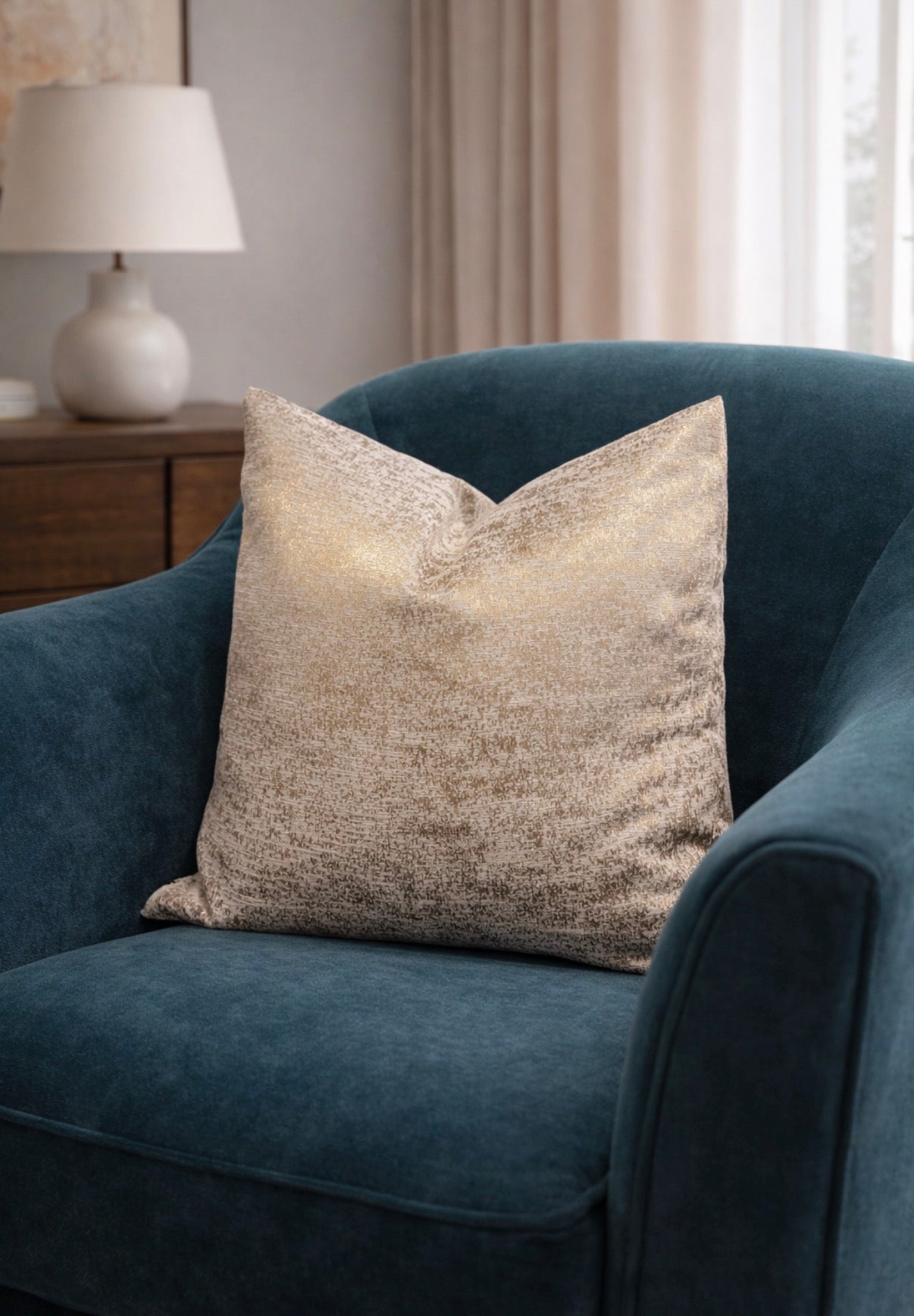 Golden silk on a blue armchair with a lamp and curtains in the background