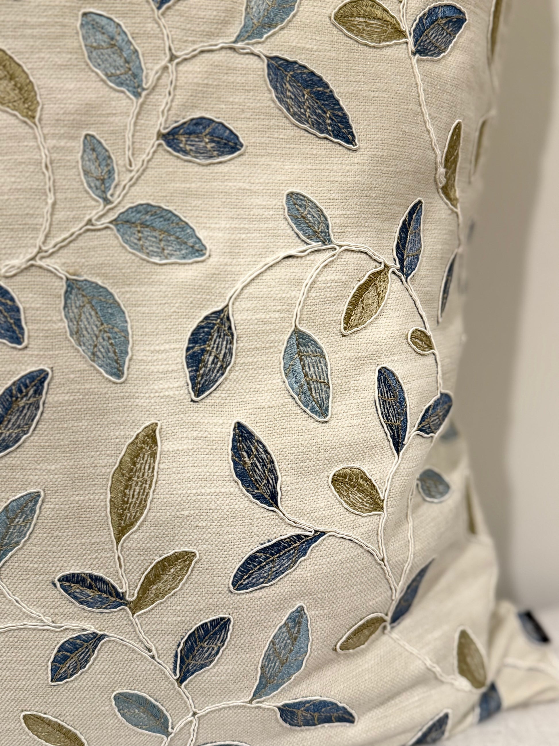 Close up of Azure Olive Cushion with embroidered navy, sage, and dusty blue leaves | interiors by zai
